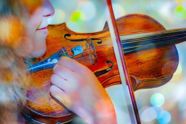 Close-up of a musician playing a violin, symbolizing passion, creativity, and lasting impact.